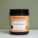 Golden Turmeric Whipped Body Butter displayed in a glass jar, featuring a soft whipped texture and nourishing blend of turmeric, rose, and plant butters for smooth, hydrated skin.