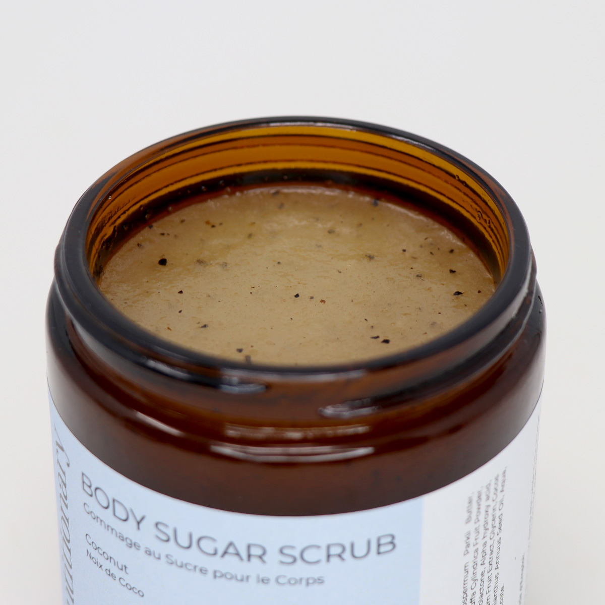 Beautitionary coconut body sugar scrub with open lid showing texture.